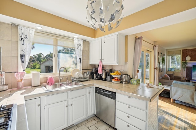 kitchen with a wealth of natural light, dishwasher, and tile countertops