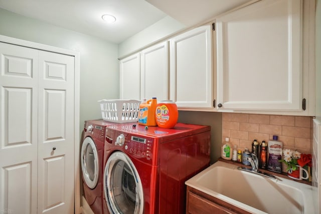 laundry area with separate washer and dryer, cabinets, and sink