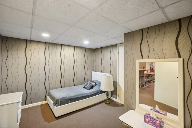 carpeted bedroom featuring a drop ceiling