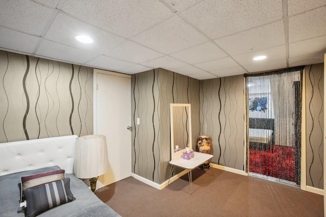 interior space featuring a paneled ceiling and carpet flooring