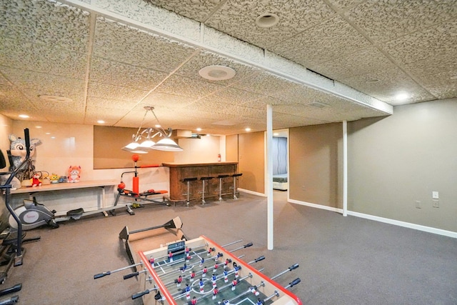 playroom with a paneled ceiling and indoor bar