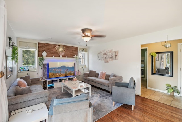 living room featuring a brick fireplace, ceiling fan, and hardwood / wood-style flooring