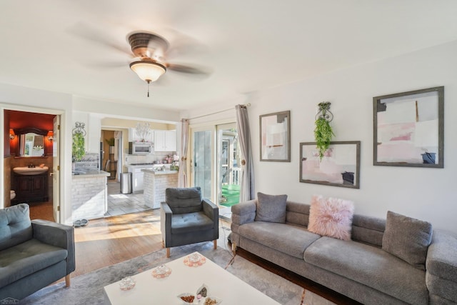 living room with ceiling fan and light wood-type flooring