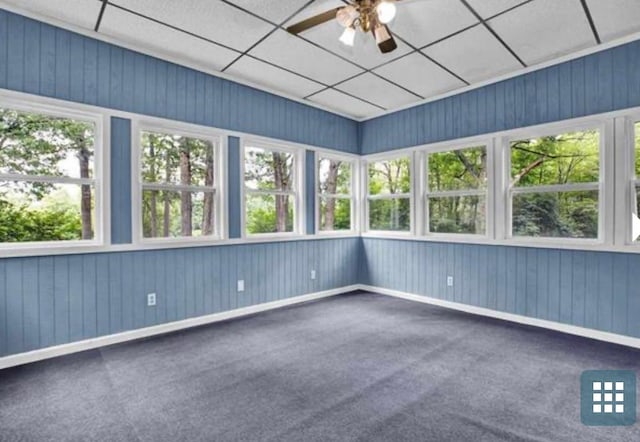 unfurnished sunroom with a paneled ceiling, ceiling fan, and plenty of natural light