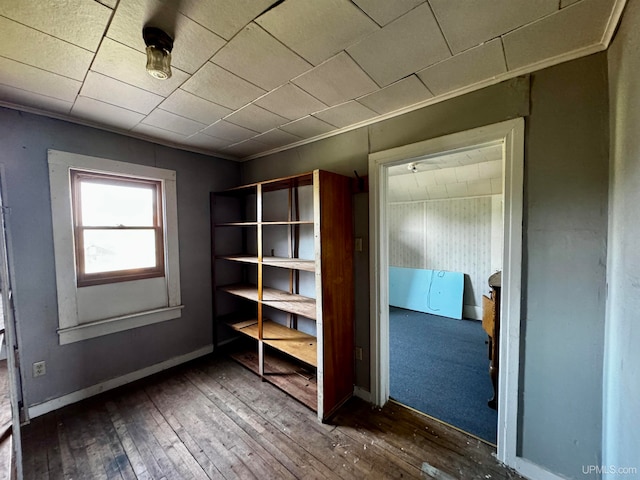 interior space featuring crown molding and dark wood-type flooring