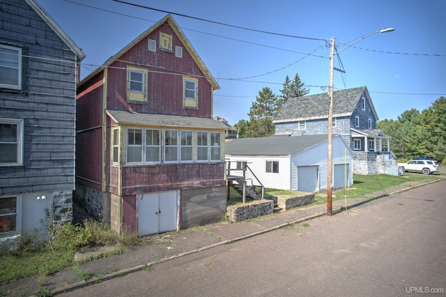 52 Senter St, Ahmeek, MI 49901 - view of front of house with a garage, stairway, and an outdoor structure