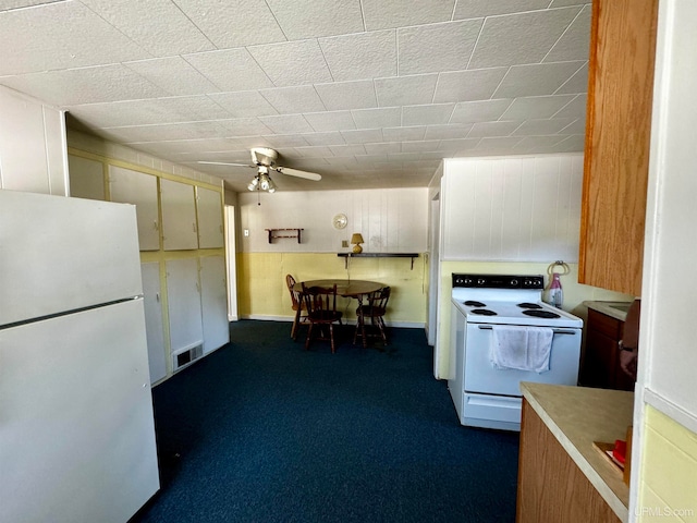 kitchen featuring white appliances, dark carpet, and ceiling fan