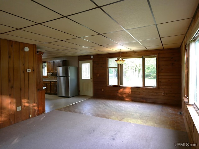 unfurnished living room with plenty of natural light and a paneled ceiling