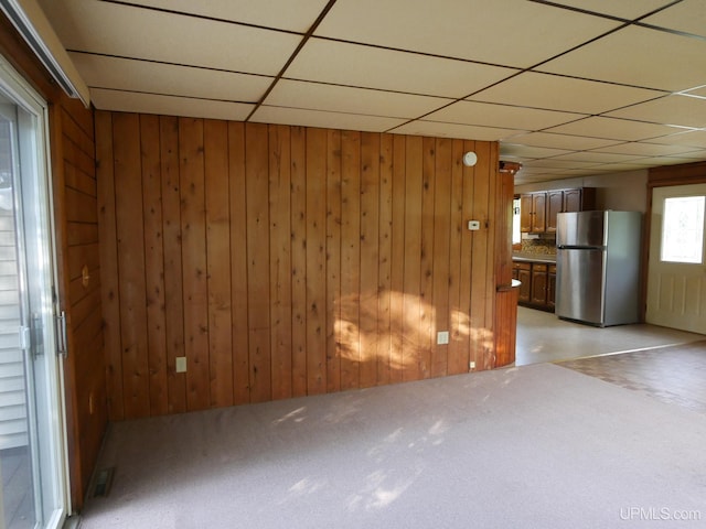 interior space featuring wood walls and a paneled ceiling