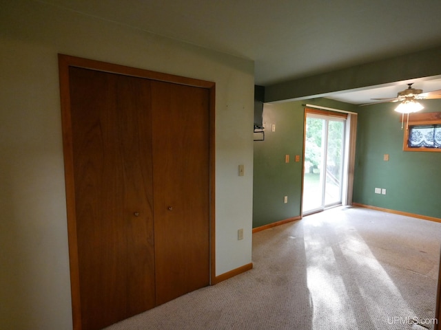 unfurnished bedroom with light carpet, access to outside, and ceiling fan