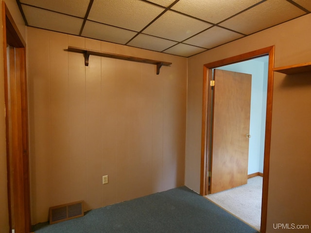 empty room featuring a drop ceiling and carpet flooring