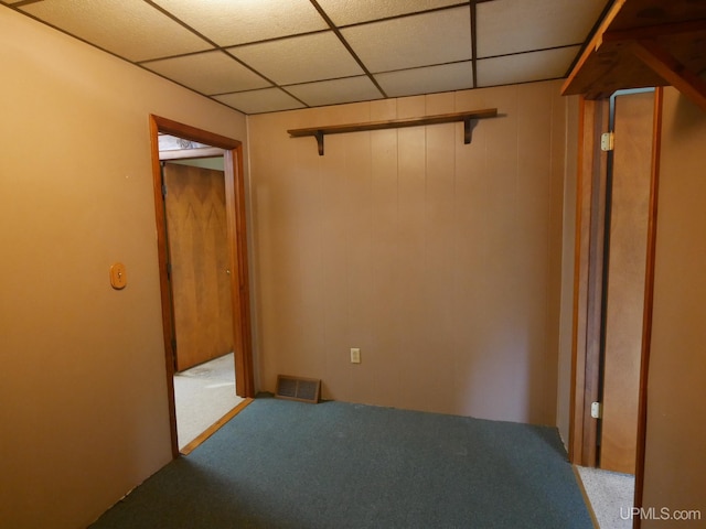 unfurnished bedroom featuring a closet, a drop ceiling, and carpet flooring