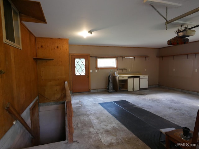 garage with a garage door opener and wood walls