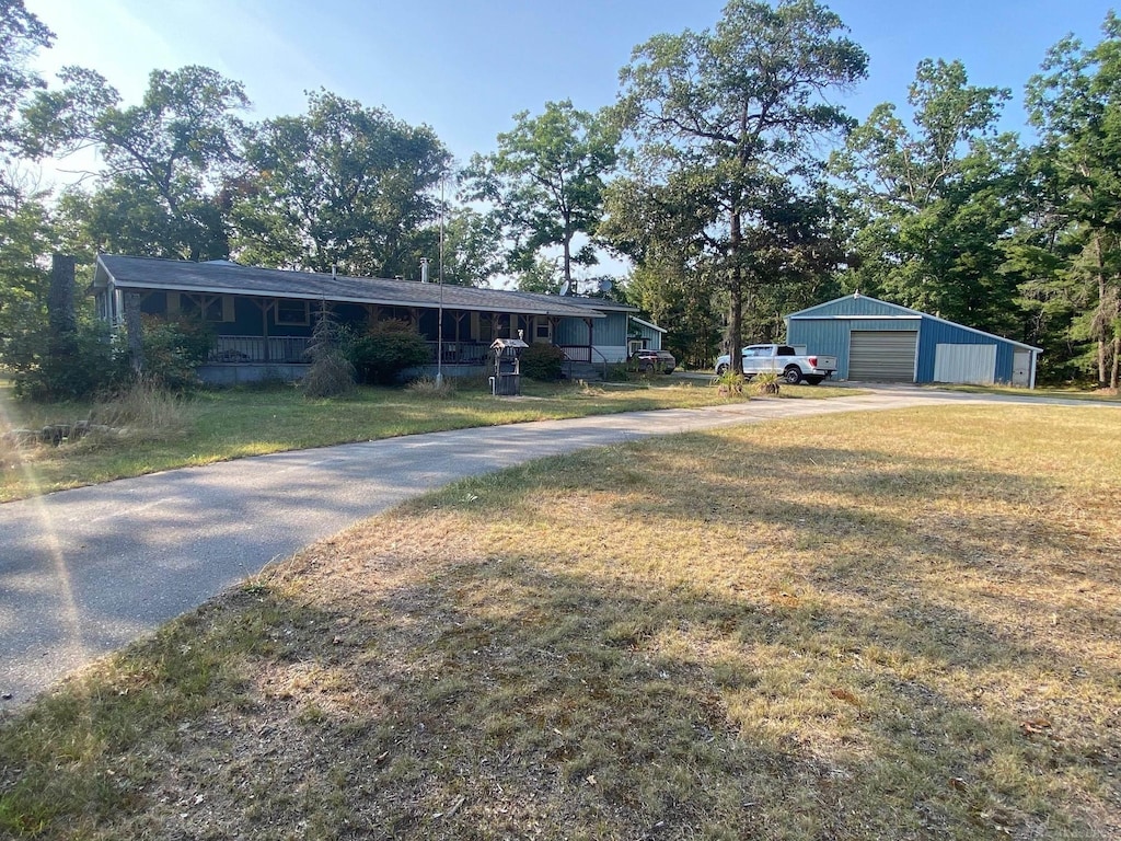 view of front facade with a front yard, an outdoor structure, and a garage