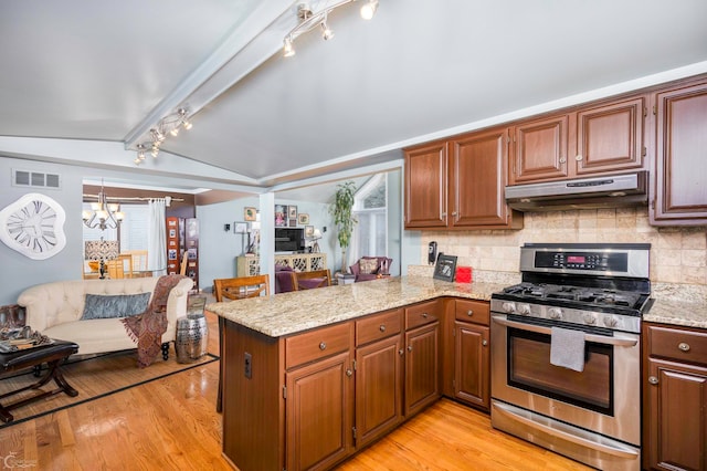 kitchen featuring vaulted ceiling with beams, kitchen peninsula, stainless steel range with gas stovetop, and extractor fan