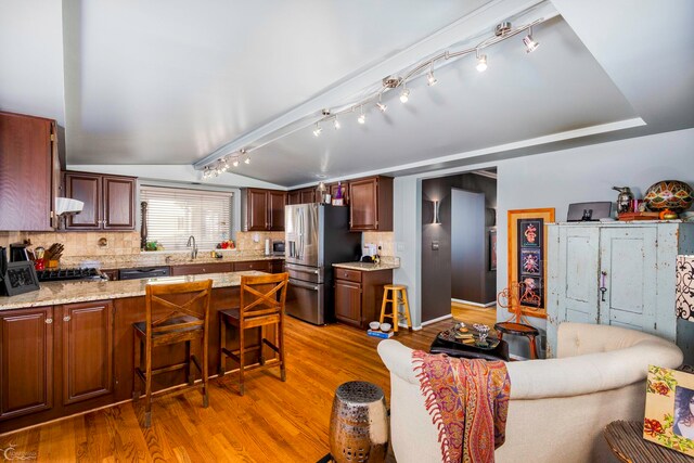 kitchen featuring track lighting, tasteful backsplash, sink, stainless steel appliances, and extractor fan