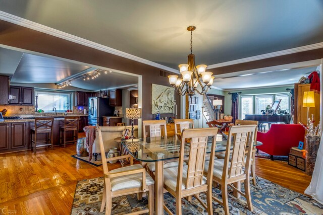 kitchen with vaulted ceiling with beams, a center island, appliances with stainless steel finishes, a breakfast bar, and a fireplace