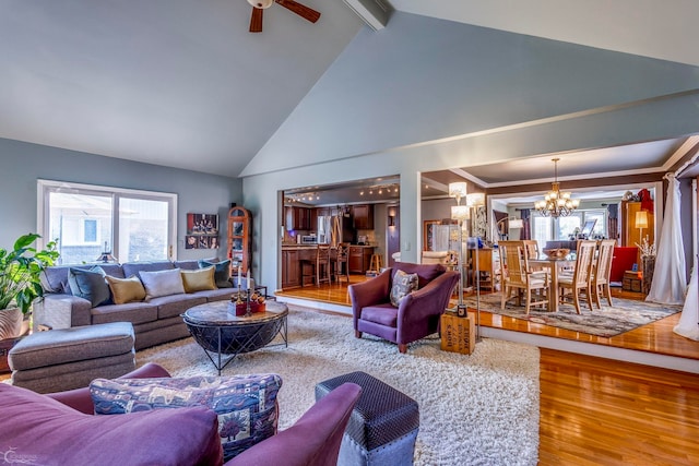 living room with wood-type flooring, beamed ceiling, ceiling fan with notable chandelier, and high vaulted ceiling