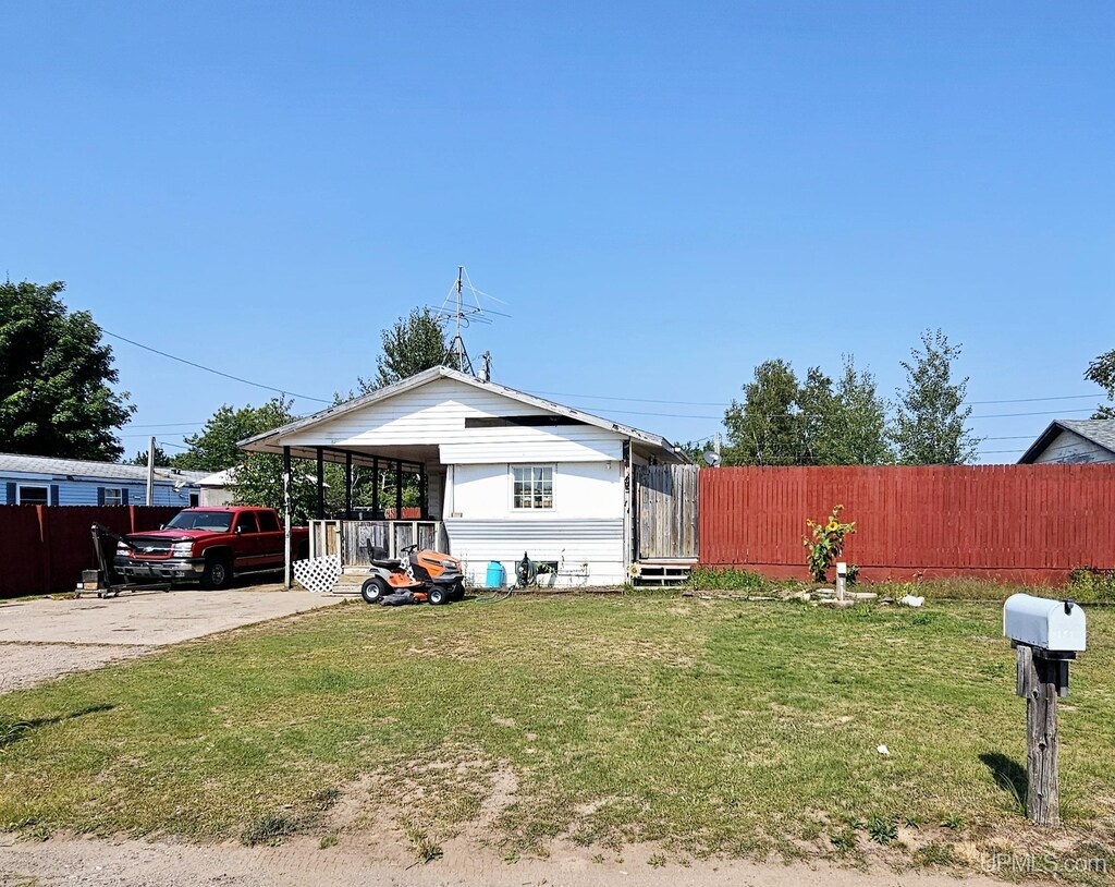 exterior space featuring fence and a front lawn