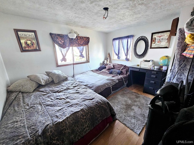 bedroom featuring hardwood / wood-style flooring and a textured ceiling