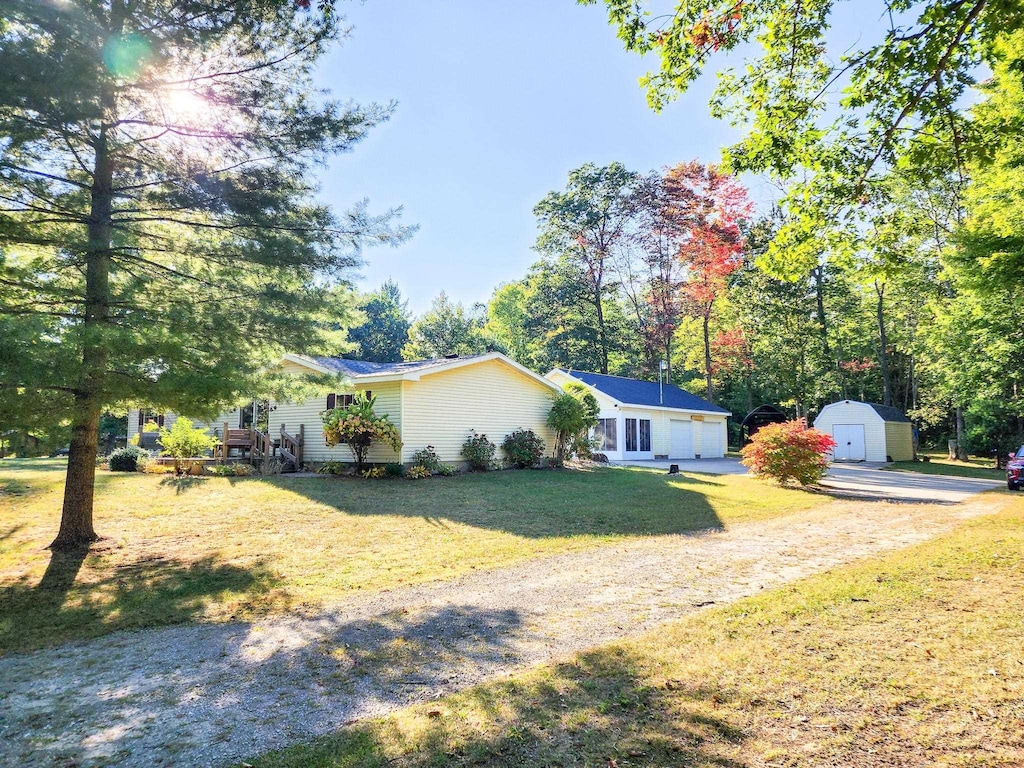 3901 E Long Lake Rd, Harrison, MI 48625 - view of front facade featuring an outdoor structure, driveway, a shed, and a front lawn