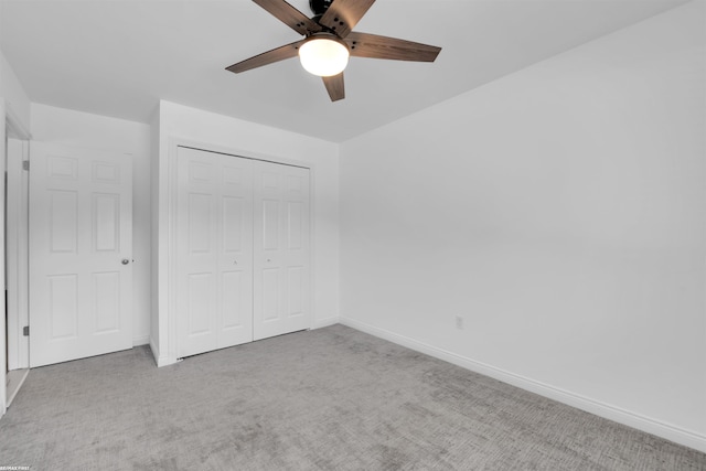 unfurnished bedroom with ceiling fan, light colored carpet, and a closet