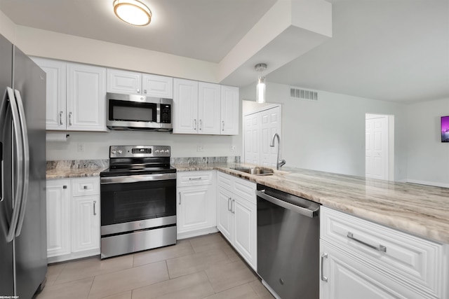 kitchen with light stone countertops, white cabinetry, sink, and stainless steel appliances