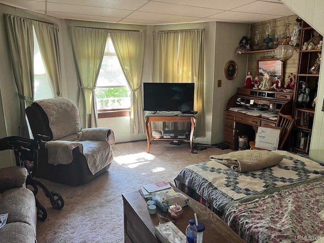 carpeted bedroom with a drop ceiling