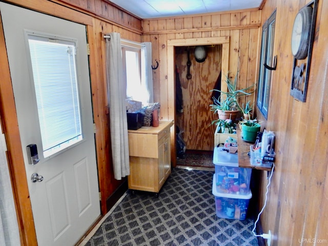 entryway with wood walls