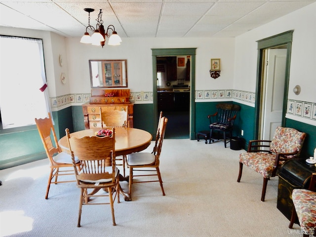 carpeted dining room featuring a chandelier