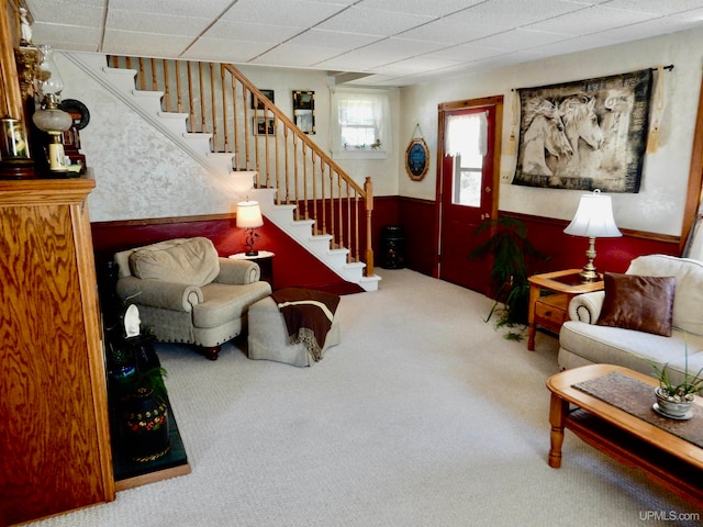 living room featuring a drop ceiling and carpet flooring