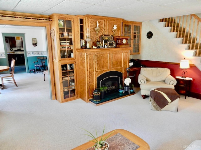 carpeted living room with a paneled ceiling