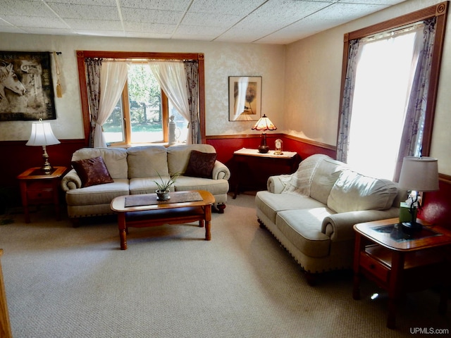 living room with carpet floors and a paneled ceiling