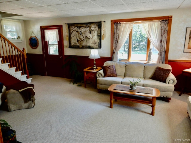 carpeted living room with a paneled ceiling