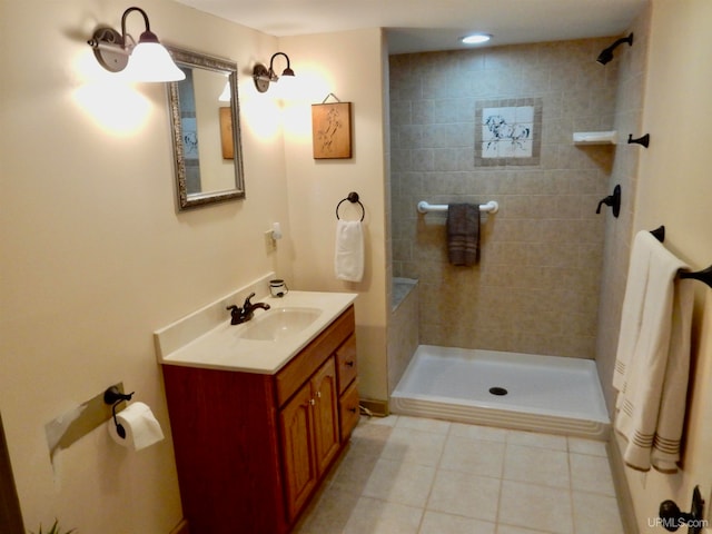 bathroom featuring vanity, tile patterned flooring, and tiled shower