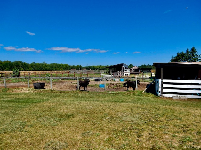 view of yard featuring an outdoor structure and a rural view