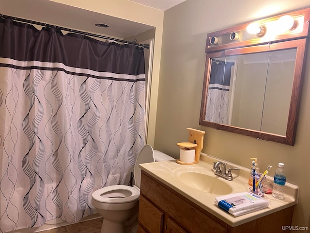 bathroom featuring curtained shower, tile patterned flooring, vanity, and toilet