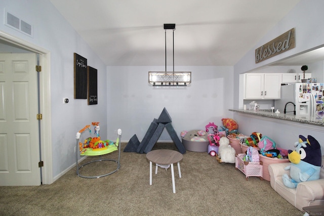 rec room featuring carpet flooring and vaulted ceiling