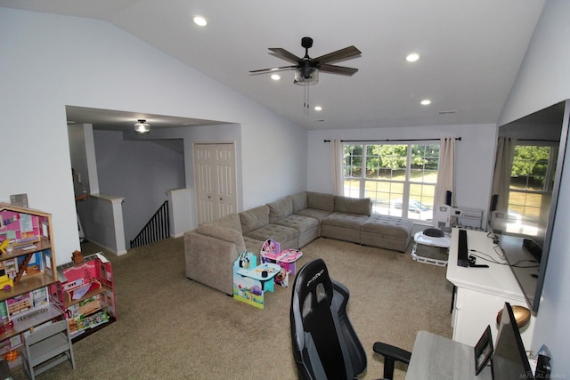 carpeted living room with ceiling fan and vaulted ceiling