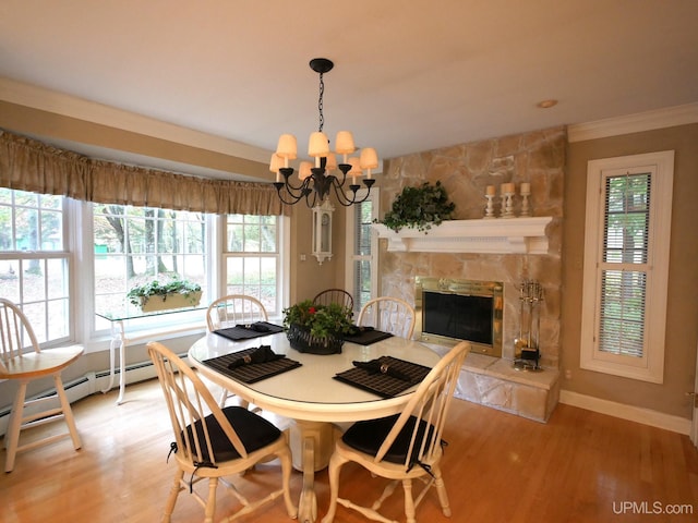 dining room featuring plenty of natural light, light wood-type flooring, and a fireplace