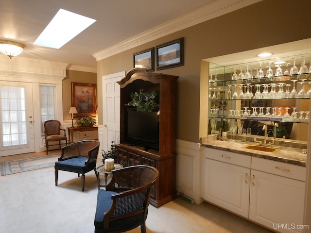 sitting room with crown molding, light carpet, and wet bar