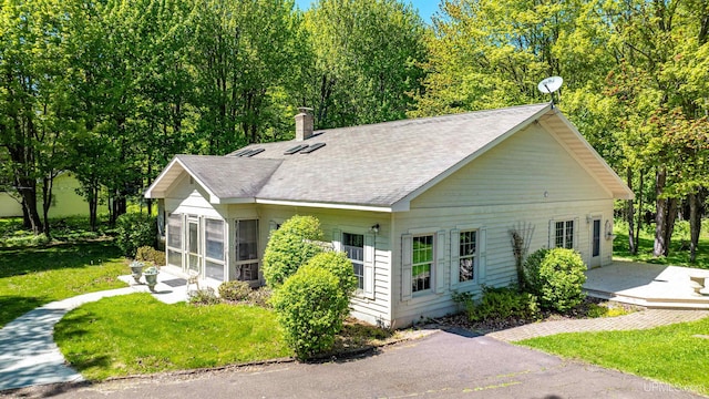 view of front of property with a front yard and a sunroom