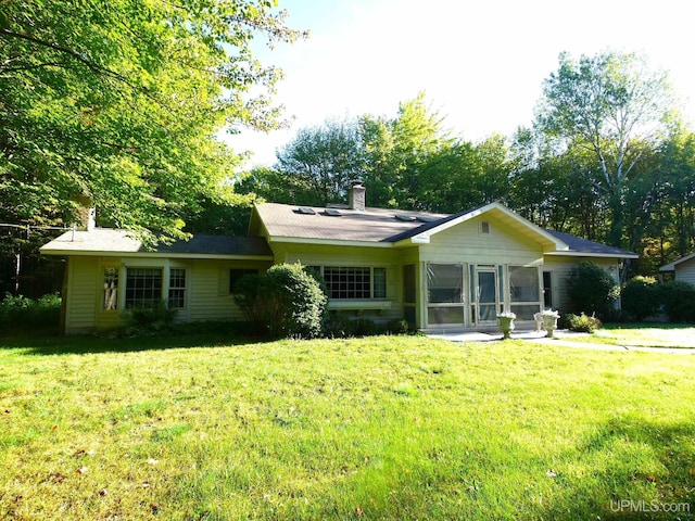 view of front of house featuring a sunroom and a front lawn