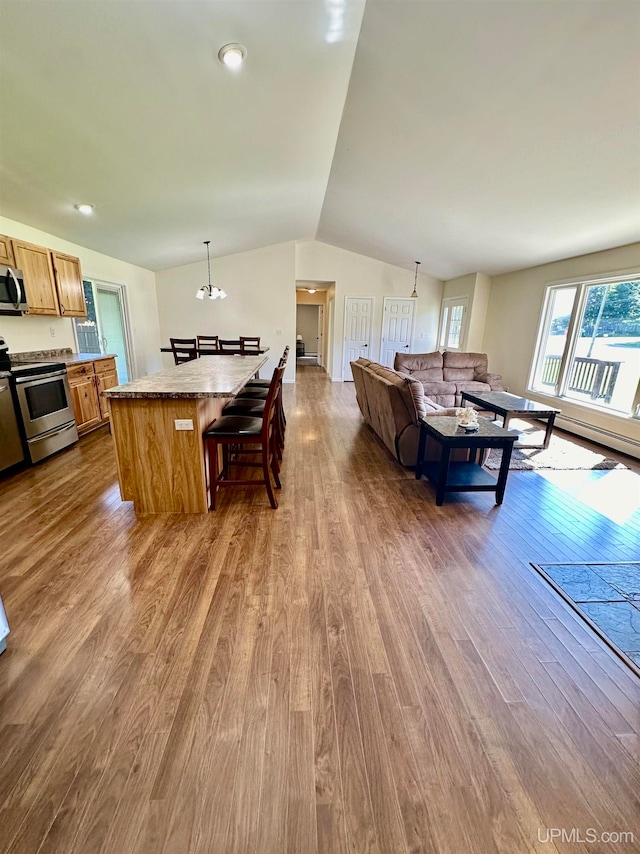 dining space featuring light wood-type flooring and vaulted ceiling