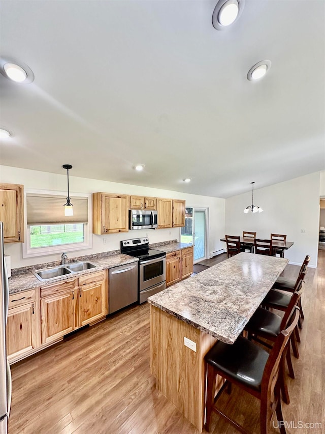 kitchen with pendant lighting, appliances with stainless steel finishes, sink, and a wealth of natural light