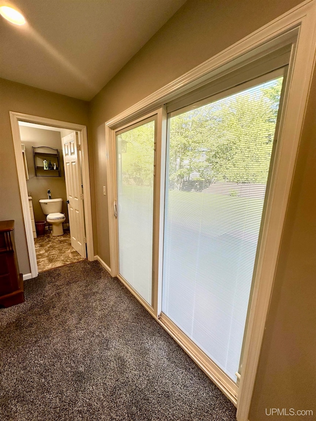 doorway with dark colored carpet