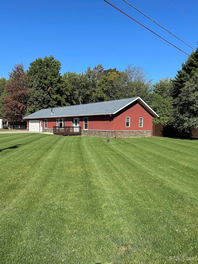 view of front of house featuring a wooden deck, a front lawn, and a garage