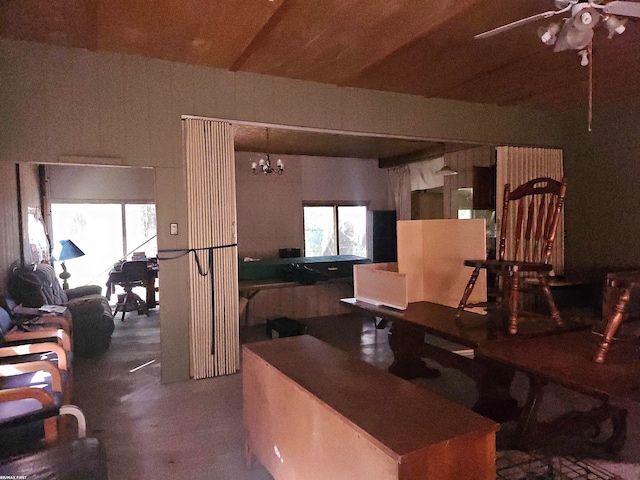 kitchen with ceiling fan with notable chandelier, lofted ceiling, and concrete flooring