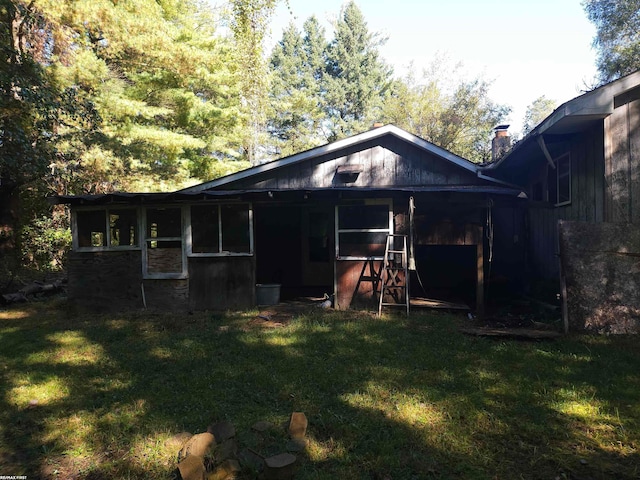 rear view of property featuring a yard