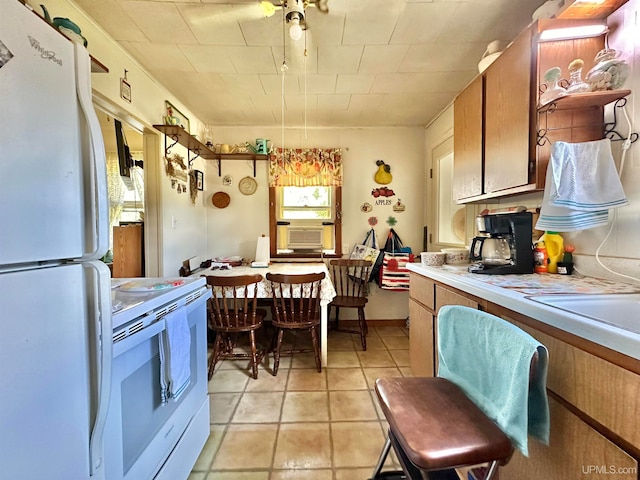 kitchen featuring light tile patterned flooring and white appliances